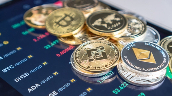 Various cryptocurrency coins displayed on top of a informative stock market panel.