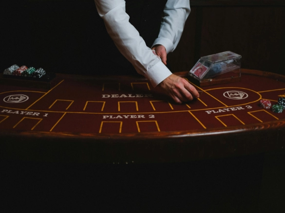 Dealer organizing cards at a casino table with chips.