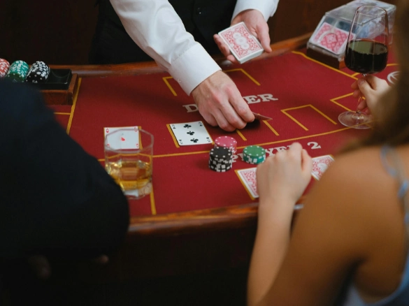 Players at a casino table while the dealer handles cards.