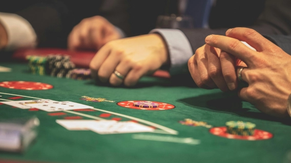People playing blackjack at a casino table with chips and cards.