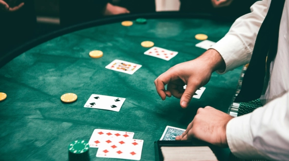 Dealer handling cards at a green casino table.